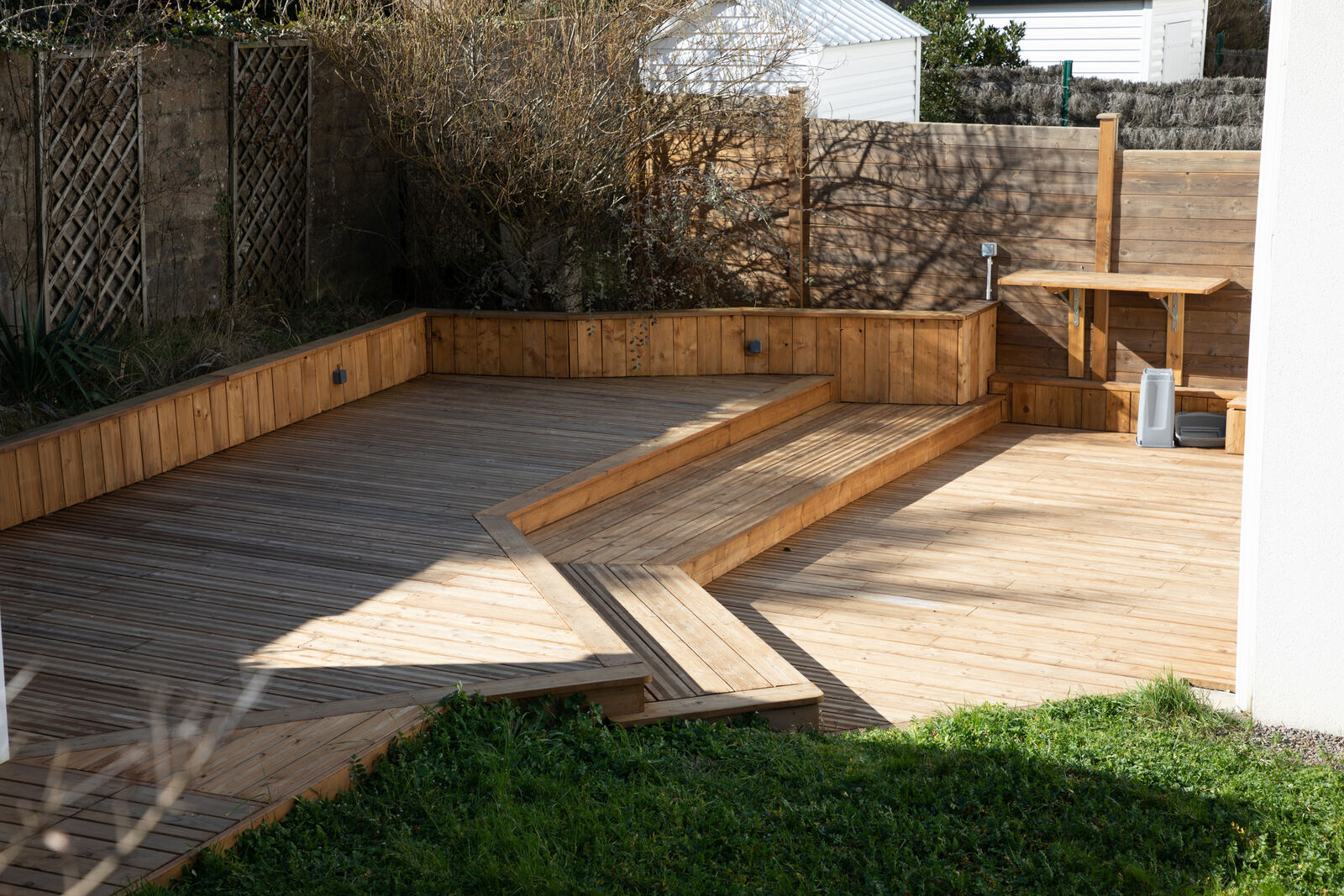 Houten terras met verhoogde borduur in de tuin