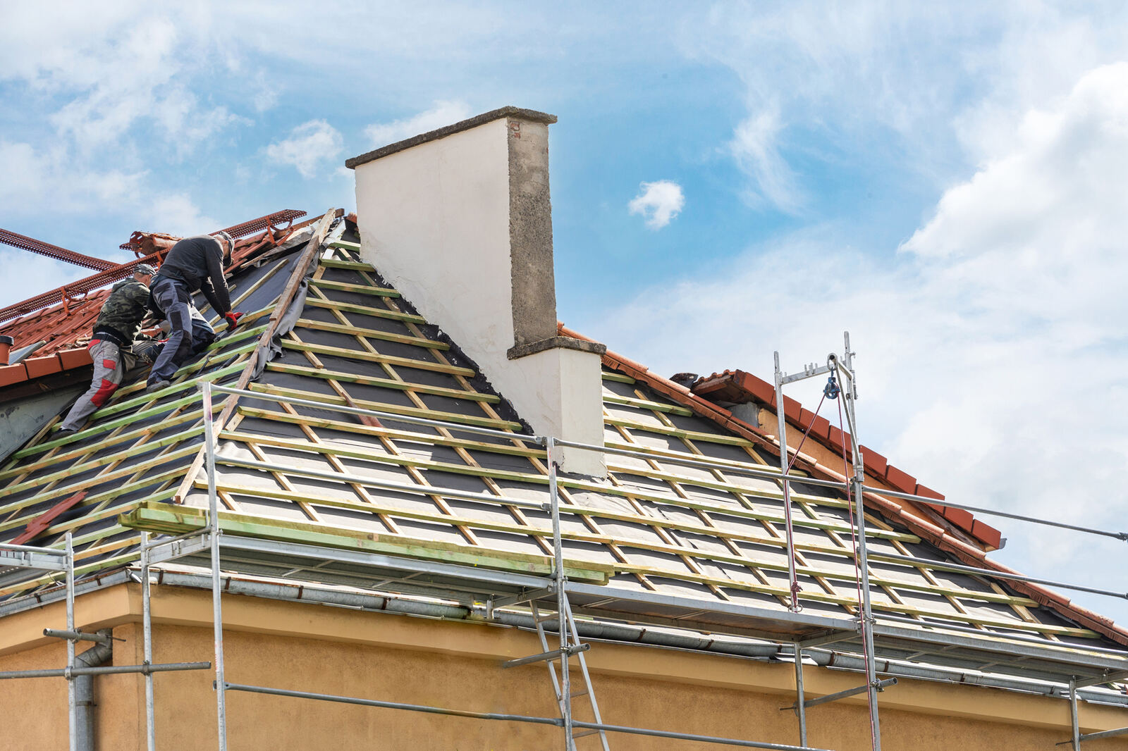 Dak in renovatie met rode pannen